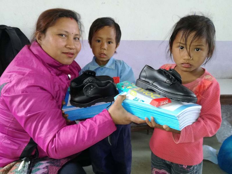 Twee leerlingen ontvangen hun schooluniformen gefinancierd door de stichting Bungamati Foundation Nepal